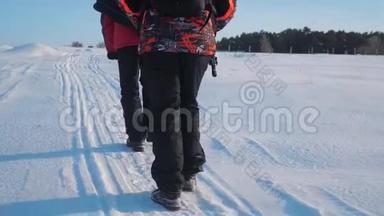 团队合作。 男游客摄影师冬天乘三脚架爬山顶山顶山顶群去下雪